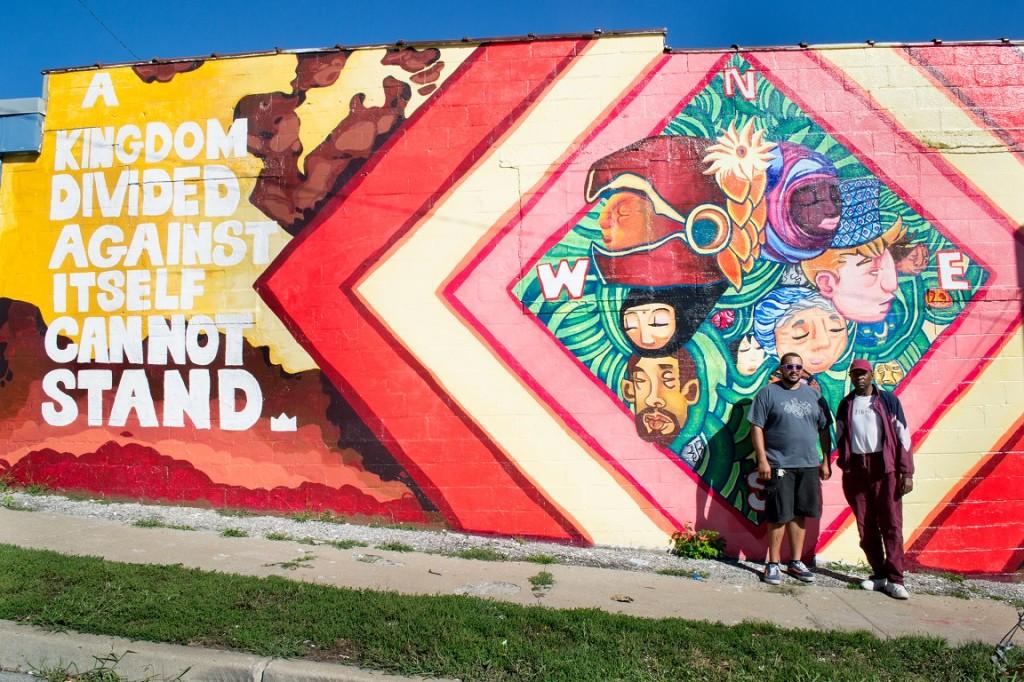 Daniels poses with a neighborhood beneficiary of his latest mural off Independence and Norton