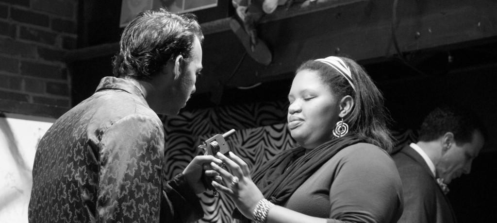(Left to Right) Matt Shaw, Brandis Outlaw and Marcelo Henriques in "Art of Murder". Shaw pointing a gun at Outlaw while Henriques is drinking at a bar.