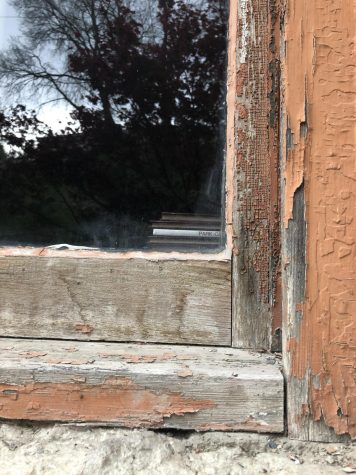 Window frame with rotted wood and chipped paint