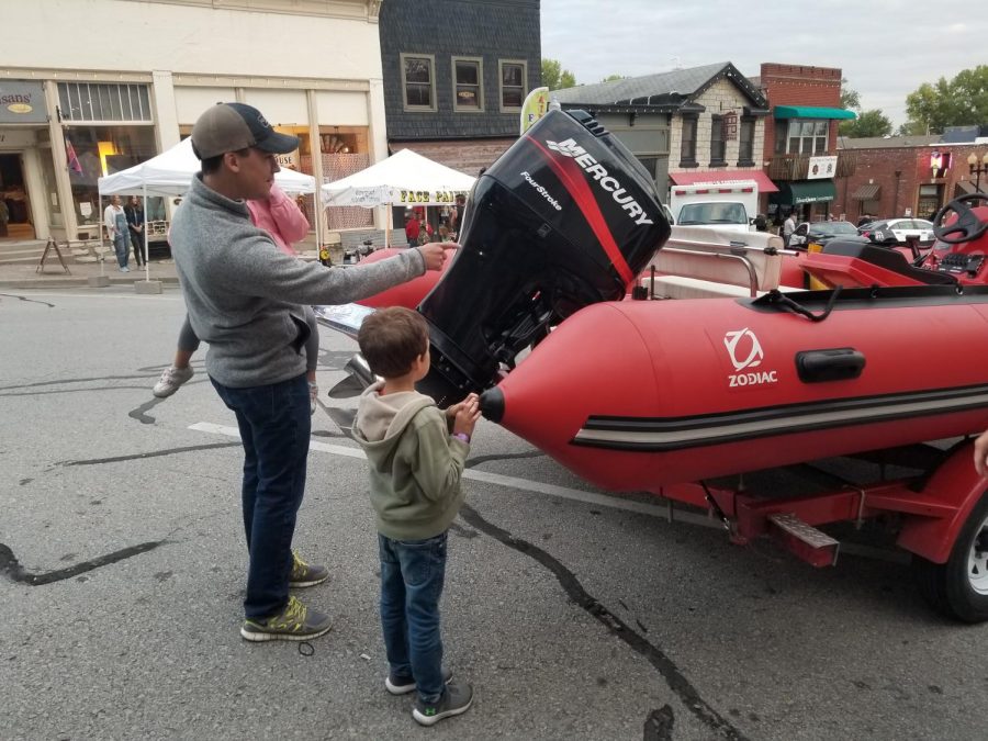 Lucas Ramon, age 7, asks his father questions about the Parkville search and rescue boat.