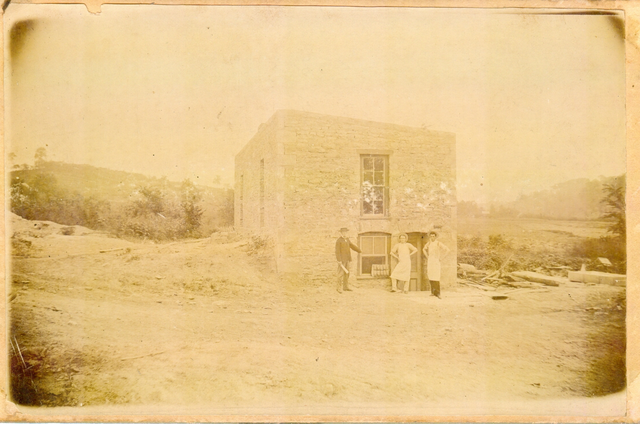 Old+photograph+from+the+late+1800s.+Three+people+stand+in+front+of+the+old+bakery+building.