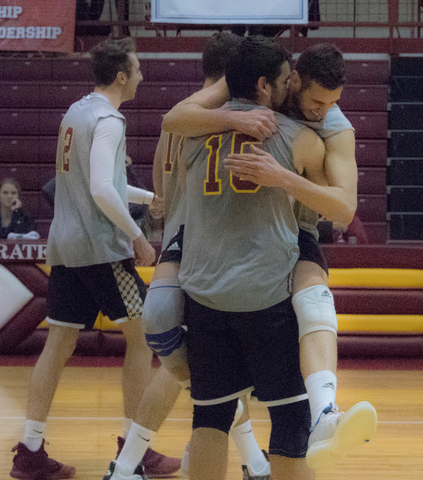 Foreground: Andrea Maggio, senior outside hitter, jumping into the arms of Luciano Bucci, sophomore setter, to celebrate another point scored.