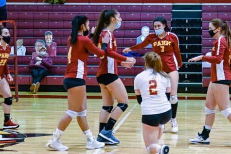 Volleyball players walk towards each other.