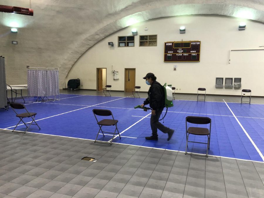 Campus workers disinfect seats before Covid testing begins. 