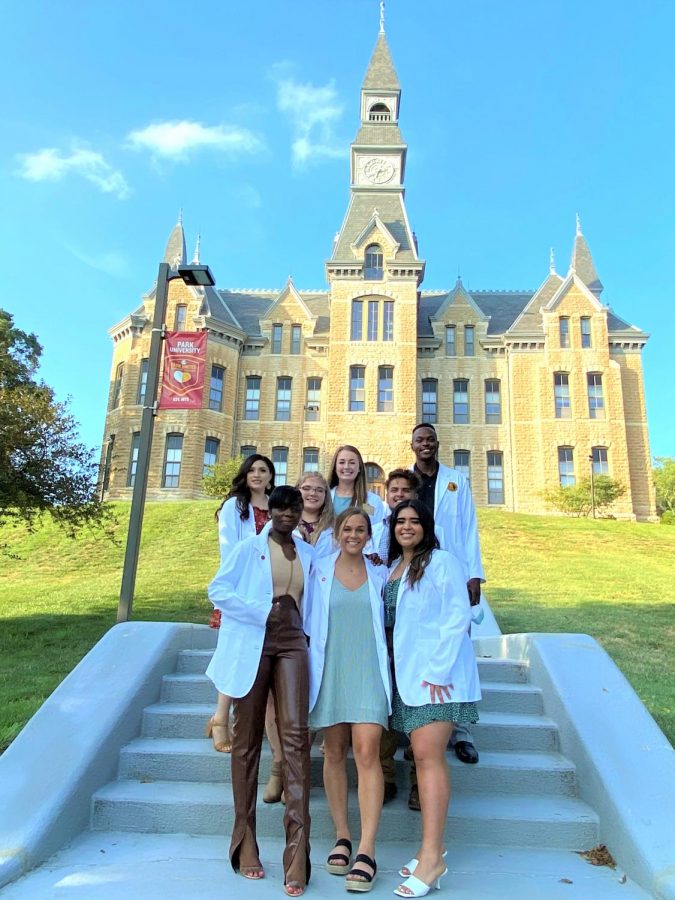 nursing students in white coats outside MacKay Hall on Park University campus